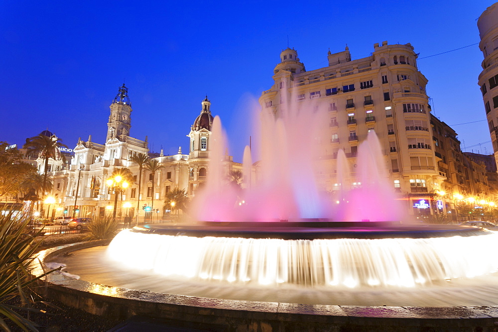 Illuminated fountain on Plaza del Ayuntamineto with town hall at dusk, Valencia, Comunidad Valencia, Spain, Europe 