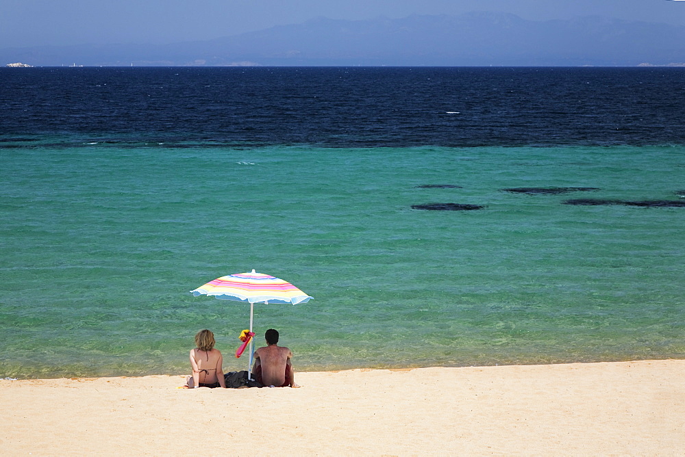 Couple under a parasol at the beach of Porto Puddu, Sardinia, Italy, Mediterranean, Europe 