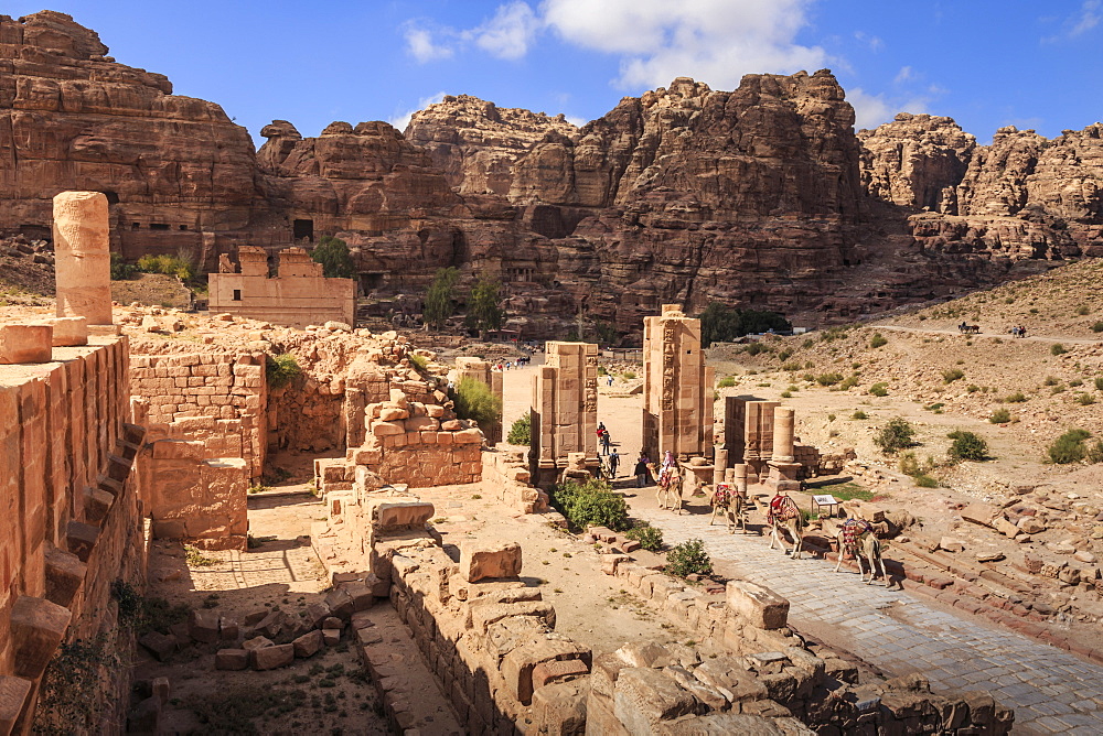 Camel train approaches Temenos Gateway with Qasr al-Bint temple, City of Petra ruins, Petra, UNESCO World Heritage Site, Jordan, Middle East