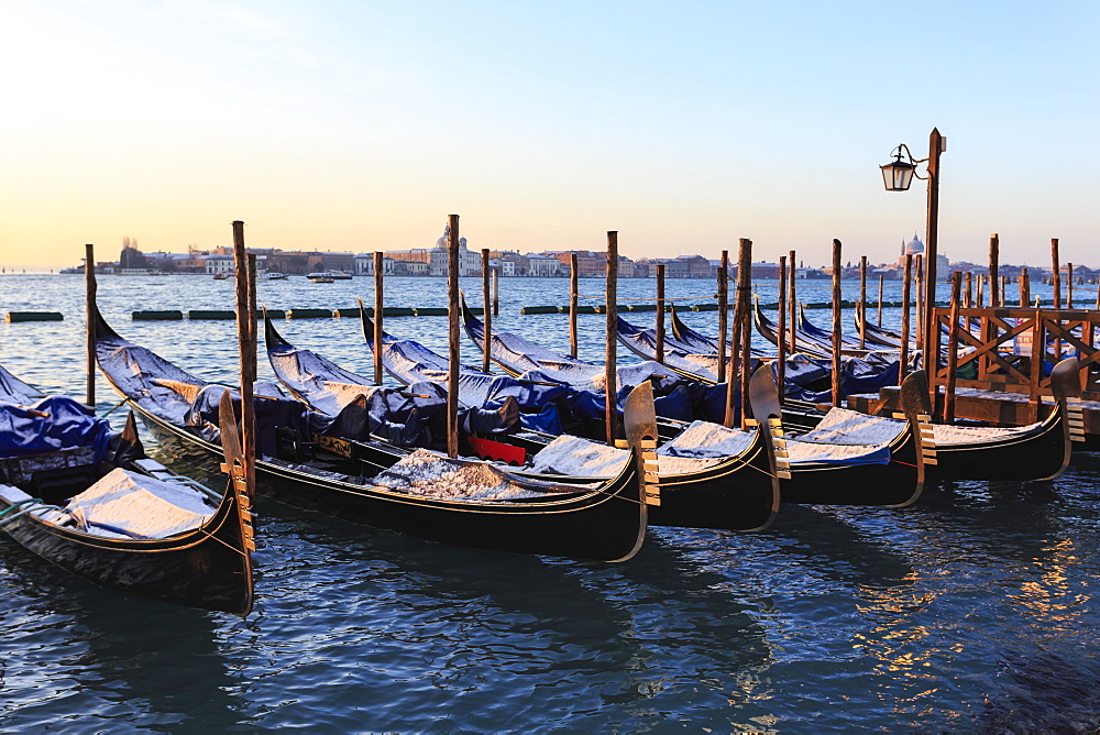 Gondolas covered in snow with view to La Guidecca, sunrise, Venice, UNESCO World Heritage Site, Veneto, Italy, Europe