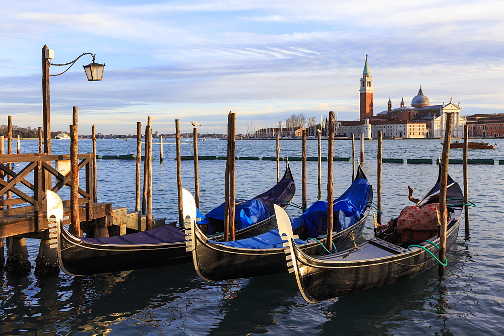 Gondolas, San Marco waterfront at sunset in winter, view to San Giorgio Maggiore, Venice, UNESCO World Heritage Site, Veneto, Italy, Europe