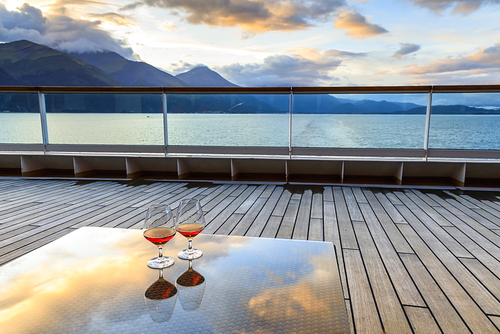 Glowing cognac (brandy) reflections, glass table at sunset, cruise ship stern, Resurrection Bay, Kenai Peninsula, Alaska, United States of America, North America