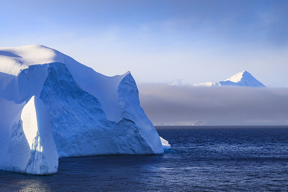 Huge iceberg, and mountain, clearing mist, Bransfield Strait, near South Shetland Islands and Antarctic Peninsula, Antarctica, Polar Regions