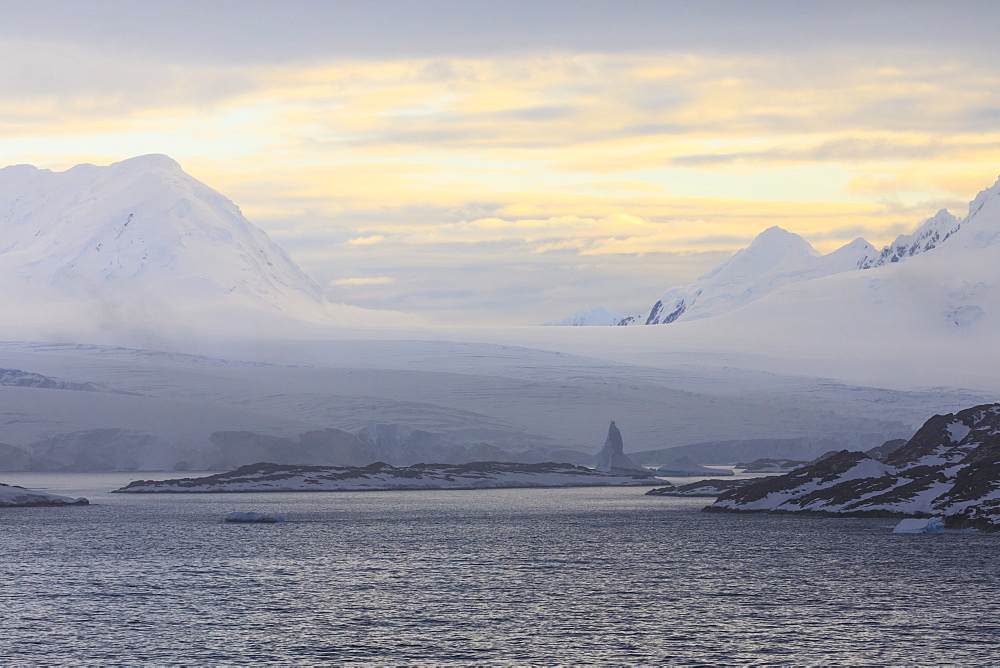 Sunrise over misty mountains, tidewater glaciers and icebergs, Anvers Island, Antarctic Peninsula, Antarctica, Polar Regions