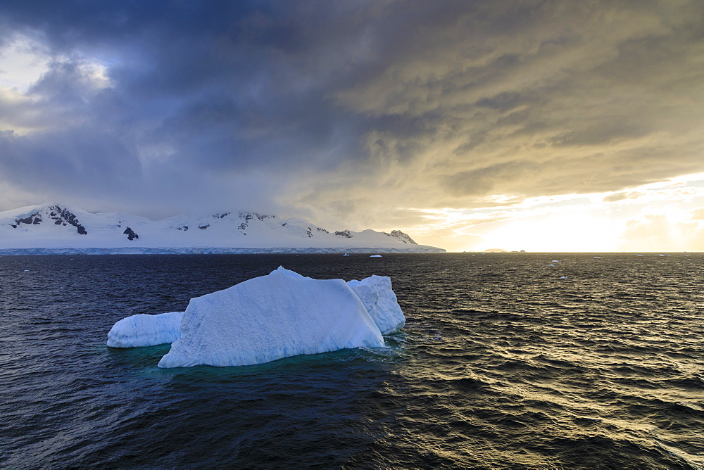 Blue iceberg at sunset, with interesting cloud formations, Gerlache Strait, Antarctic Peninsula, Antarctica, Polar Regions