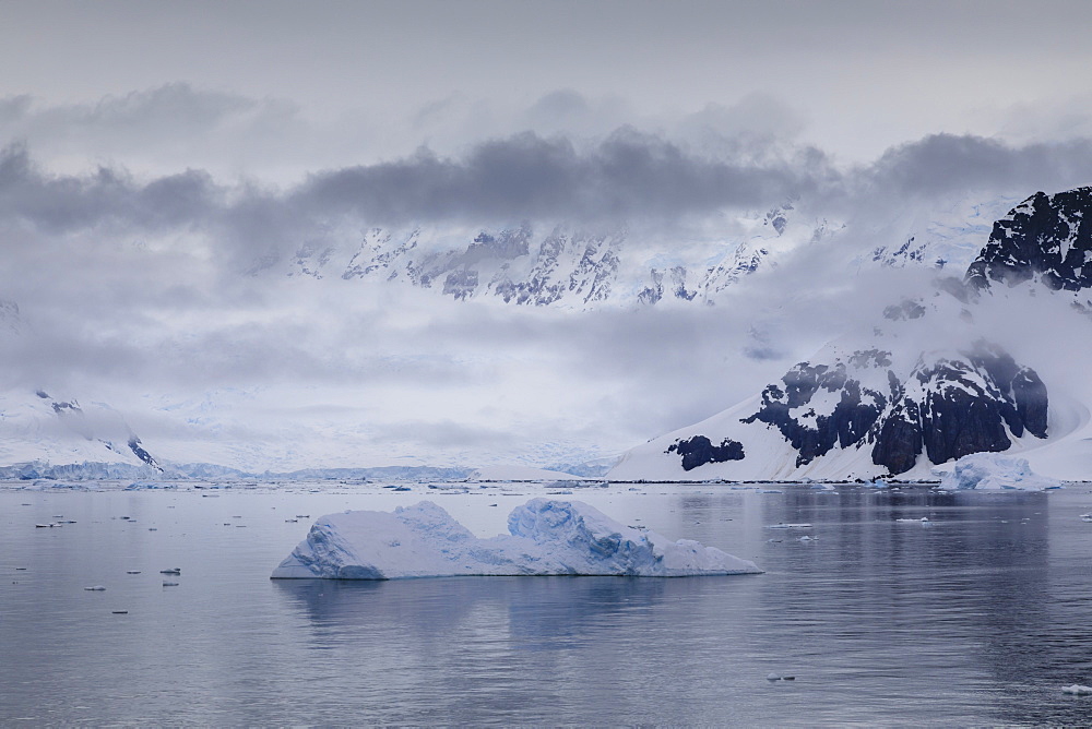 Low lying mist and clouds over mountains, glaciers and icebergs of Paradise Bay, calm waters, Antarctic Peninsula, Antarctica, Polar Regions