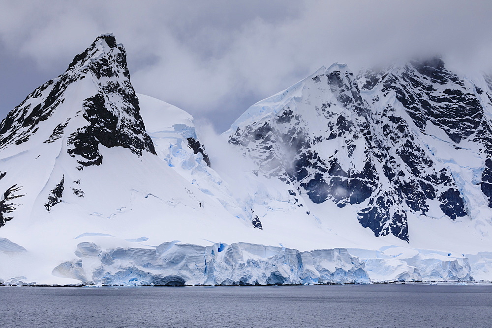 Low lying clouds over the cathedral mountains and glaciers of Paradise Bay, Antarctic Peninsula, Antarctica, Polar Regions