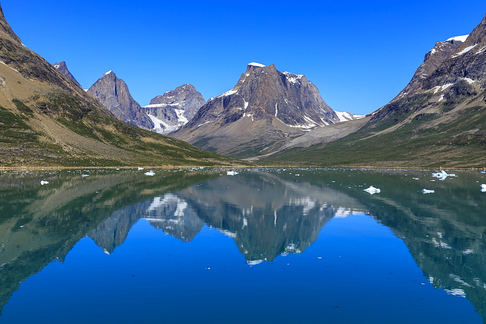 Reflections, beautiful mountains, rugged South Skjoldungen Fjord and Island, glorious weather, remote South East Greenland, Denmark, Polar Regions