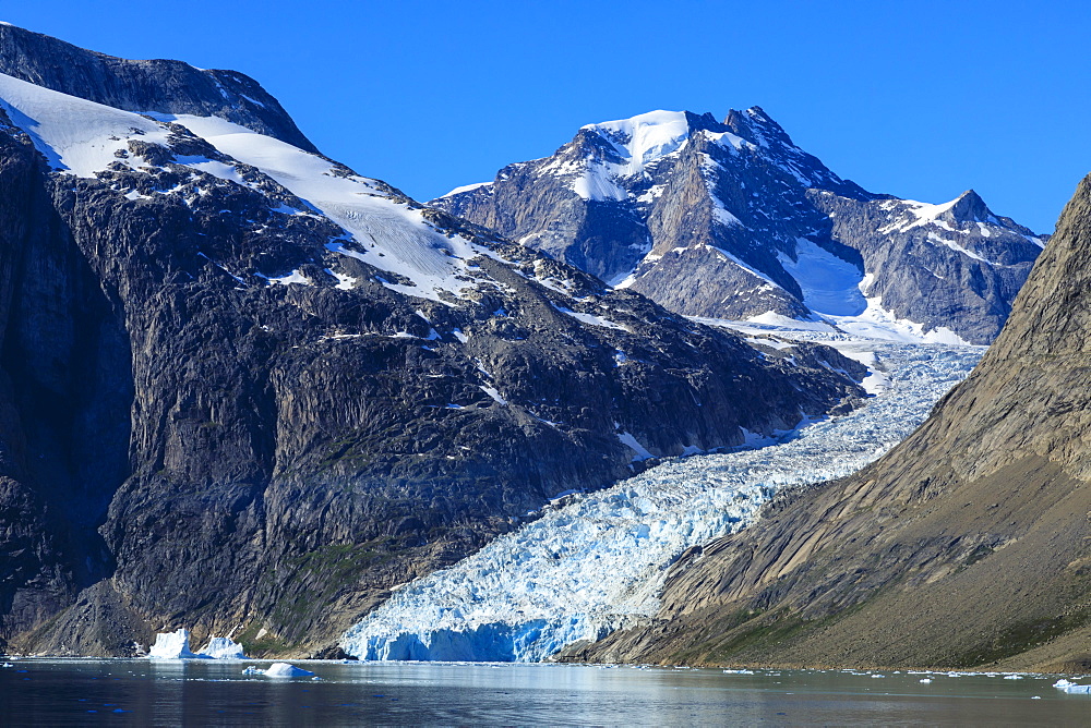 Mountains and tidewater glacier, rugged South Skjoldungen Fjord and Island, glorious weather, remote South East Greenland, Denmark, Polar Regions