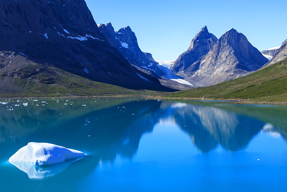 Iceberg, pyramidal peaks, reflections, blue green waters, South Skjoldungen Fjord, glorious weather, remote South East Greenland, Denmark, Polar Regions