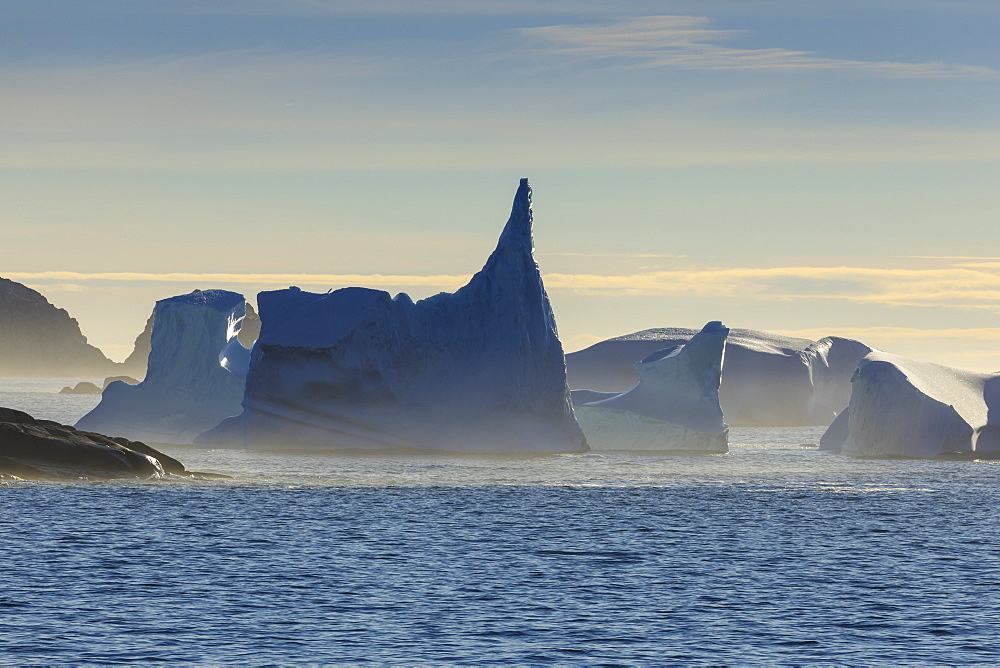 Icebergs and sea mist, entrance to Skjoldungen Fjord, early morning, King Frederick VI Coast, remote South East Greenland, Denmark, Polar Regions