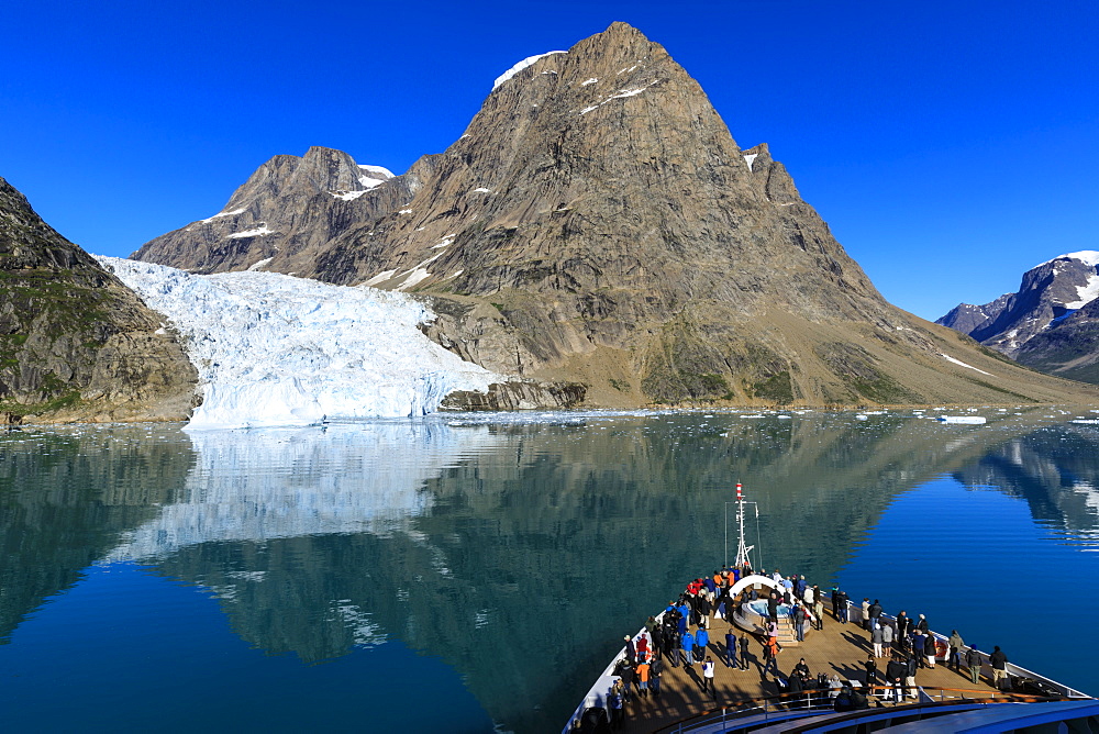 Expedition cruise ship and passengers, tidewater glacier, South Skjoldungen Fjord, glorious weather, remote East Greenland, Denmark, Polar Regions