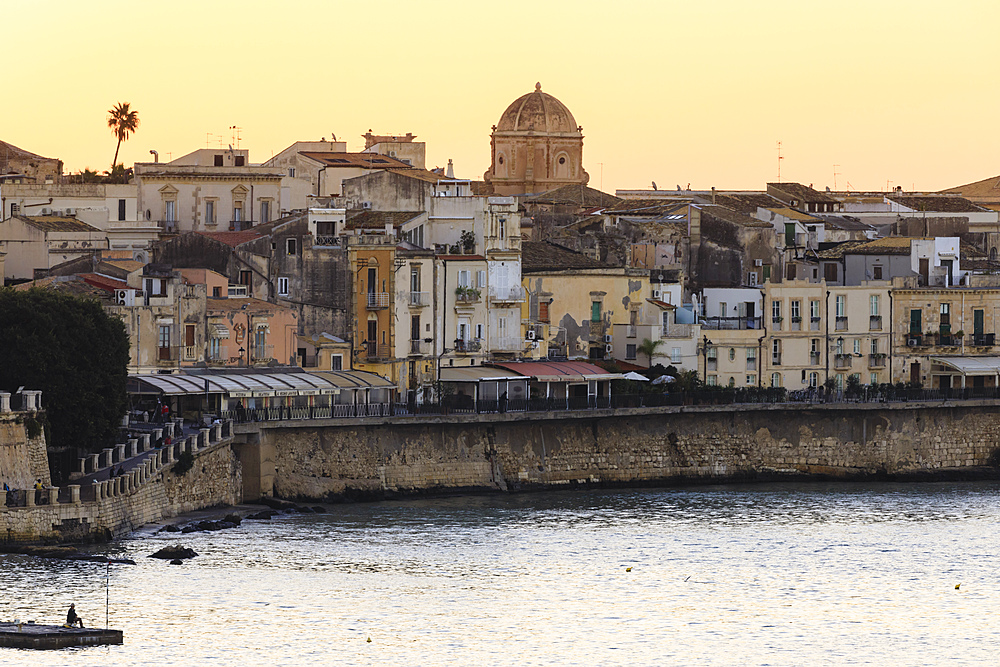 Sunrise over Ortigia (Ortygia), from the sea, fisherman on pier, Syracuse (Siracusa), UNESCO World Heritage Site, Sicily, Italy, Mediterranean, Europe