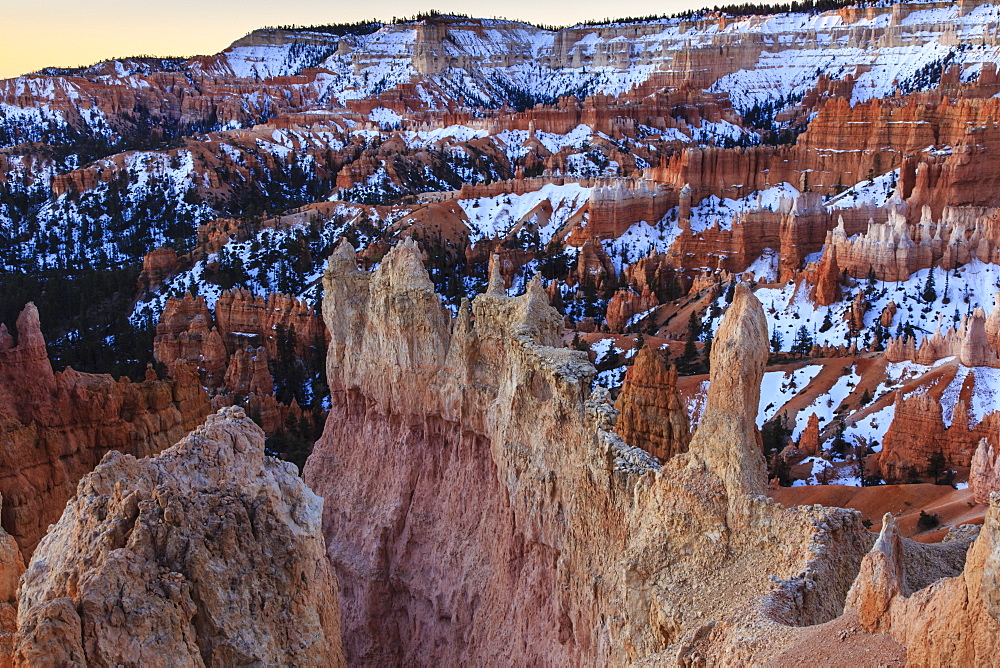 Hoodoos, rim and snow lit by dawn light in winter, Queen's Garden Trail at Sunrise Point, Bryce Canyon National Park, Utah, United States of America, North America