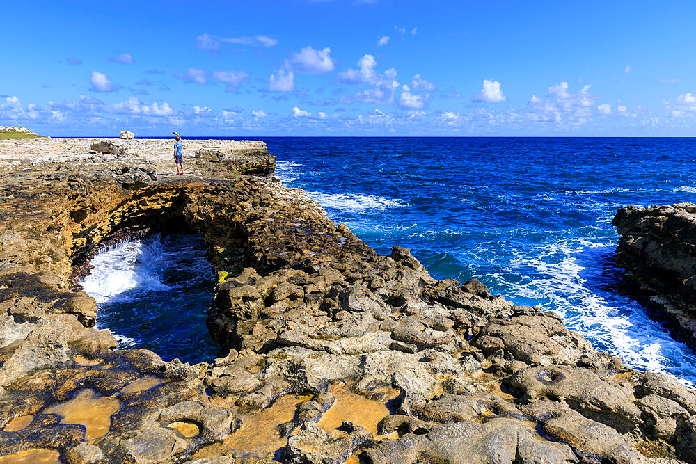 Devil's Bridge, limestone rock formation and arch, tourist takes selfie, Antigua, Antigua and Barbuda, Leeward Islands, West Indies, Caribbean, Central America