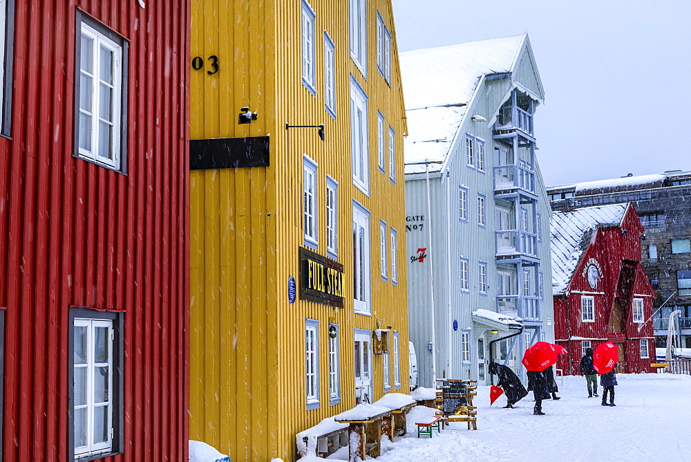 Tourists, colourful historic wooden buildings, heavy snow in winter, Tromso, Troms og Finnmark, Arctic Circle, North Norway, Scandinavia, Europe