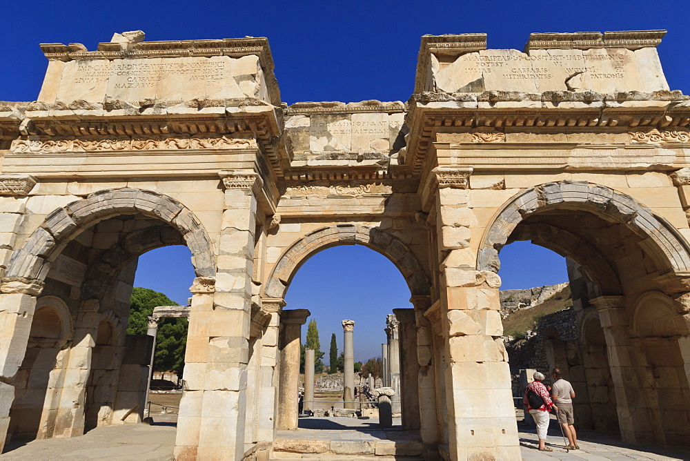 Couple at Mazeus and Mithriadates Gate, Roman ruins of ancient Ephesus, near Kusadasi, Anatolia, Turkey, Asia Minor, Eurasia