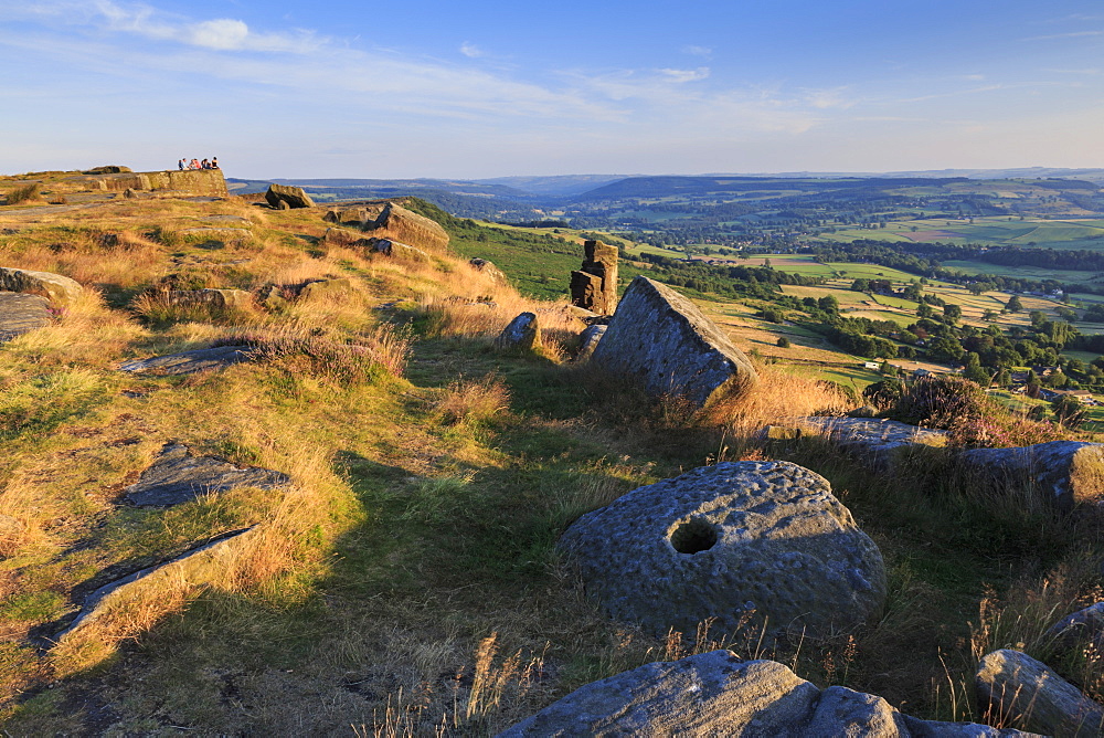 Friends on Curbar Edge with boulders and a millstone in summer, Peak District National Park, Derbyshire, England, United Kingdom, Europe