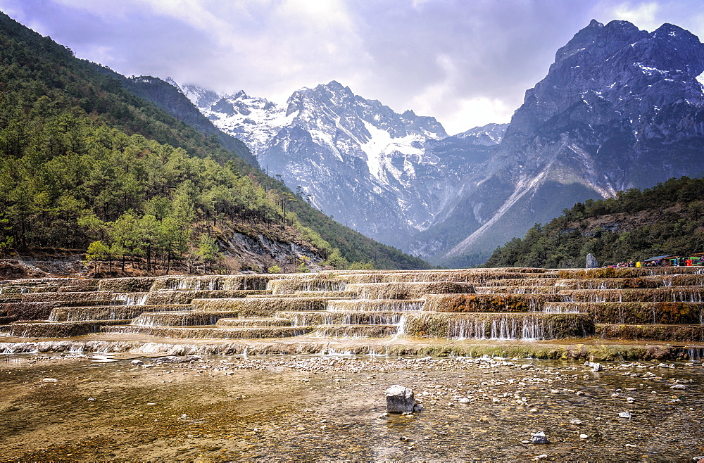 Cascading falls at Baishuihe with Jade Dragon Snow Mountain backdrop, Lijiang, Yunnan, China, Asia