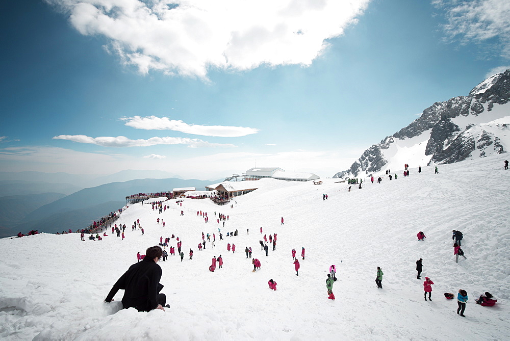 Mostly local tourists playing in the snow on top of Jade Dragon Snow Mountain near Lijiang, Yunnan province, China, Asia 