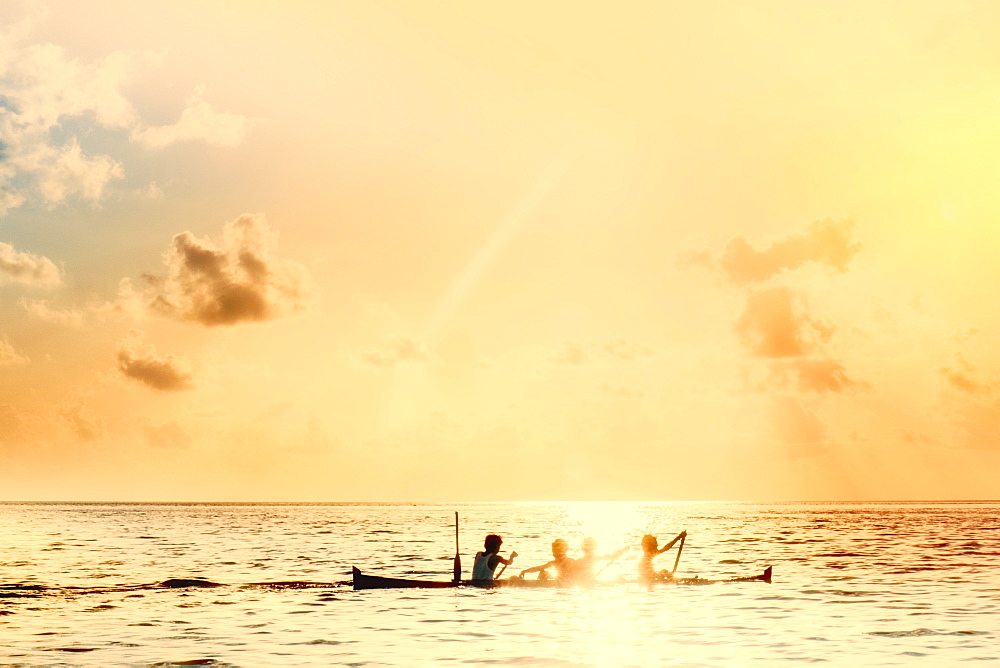 Local boys on a wooden canoe at sunset, Banda, Maluku, Spice Islands, Indonesia, Southeast Asia, Asia