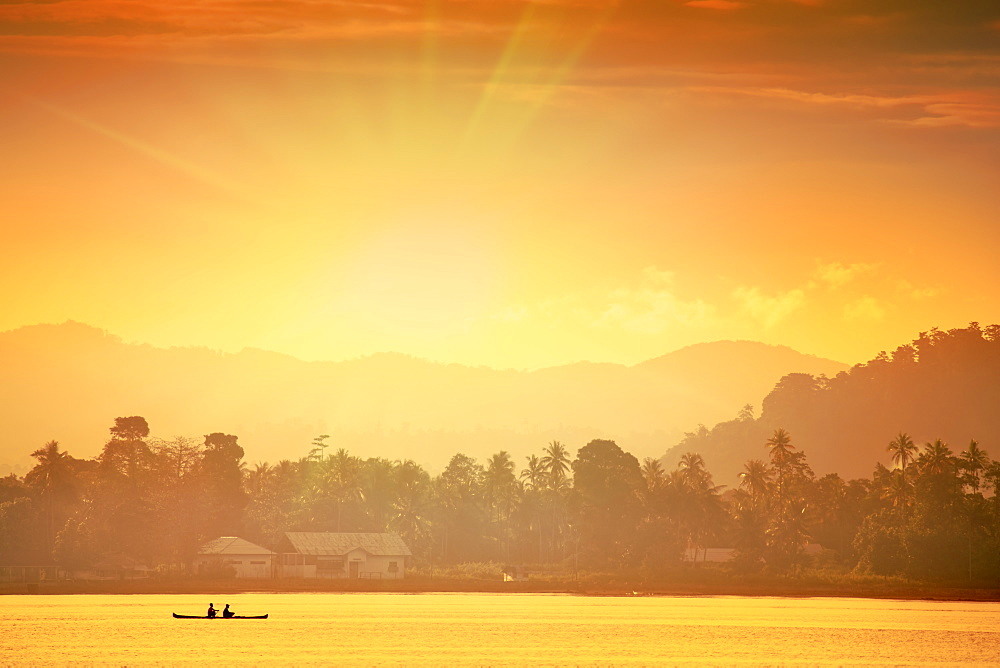 A local fisherman in a traditional canoe in front of the ridges of the Banda islands, Banda, Maluku, Spice Islands, Indonesia, Southeast Asia, Asia