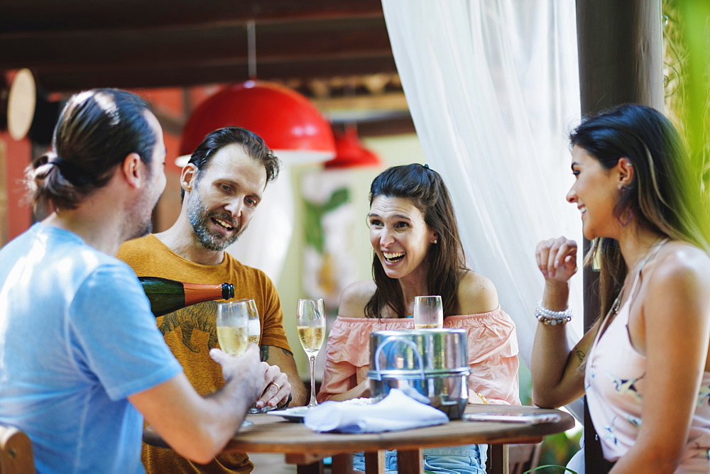 A group of friends drinking champagne together in an al fresco setting, Bahia, Brazil, South America