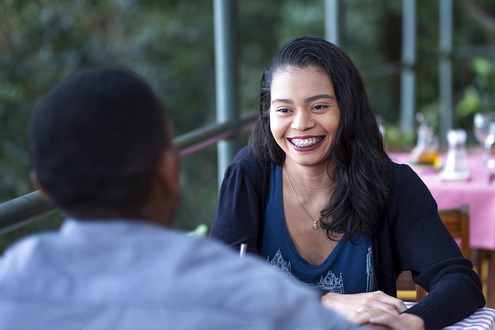 A happy multi-ethnic Latin and Black couple dining together in an al fresco restaurant, Rio de Janeiro, Brazil, South America