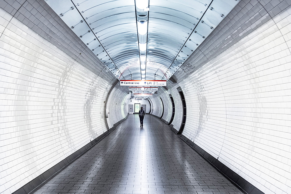 A single person walking along a corridor in an underground station during the Coronavirus lockdown, London, England, United Kingdom, Europe