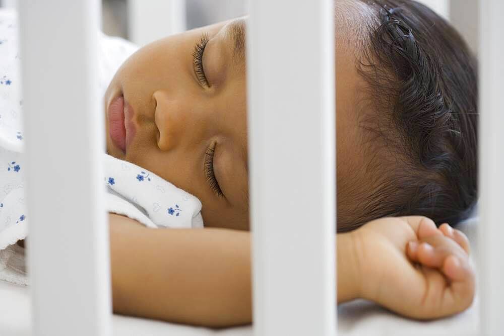 African American baby sleeping in crib