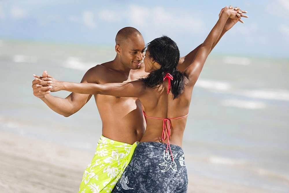 Multi-ethnic couple dancing at beach