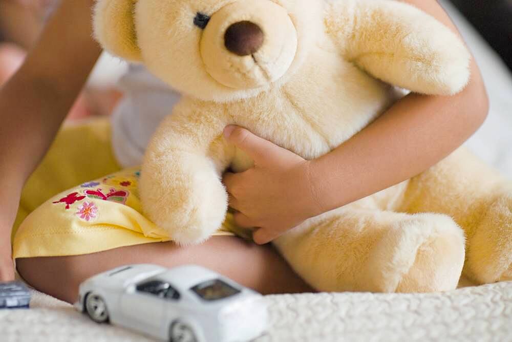 African girl holding teddy bear