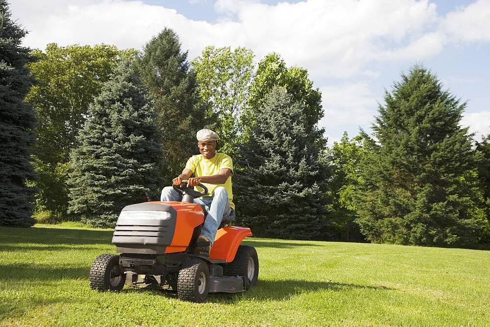 African American man mowing lawn