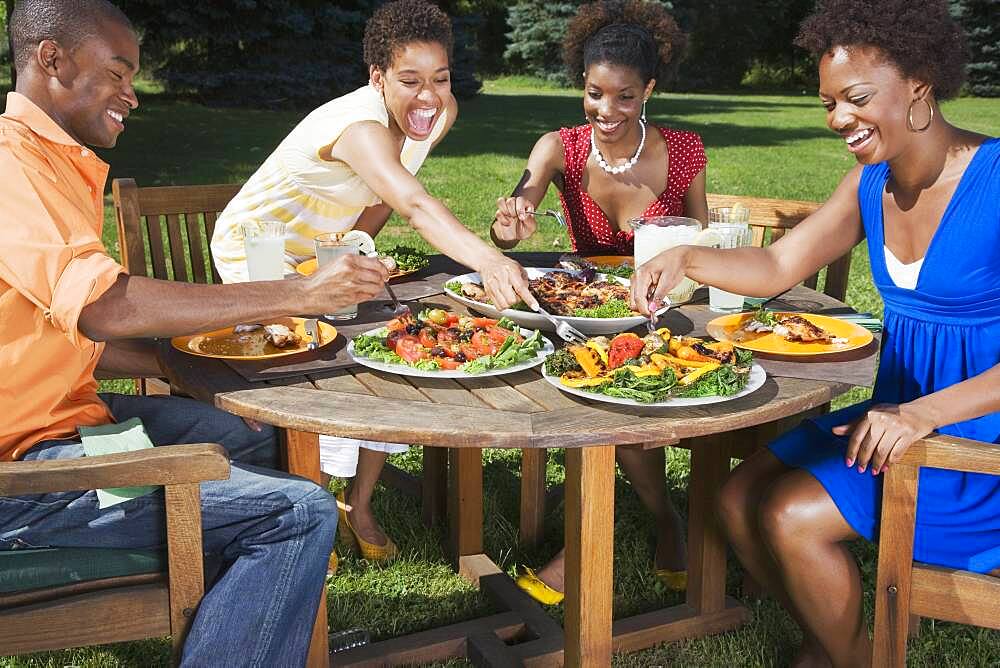 African American friends eating outdoors