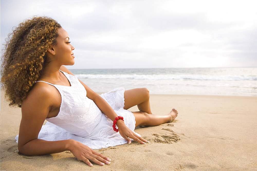 African woman laying on sand