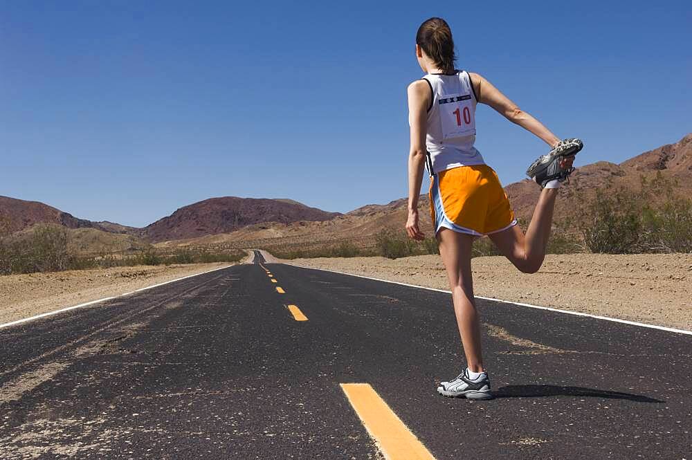 Mixed Race female runner stretching