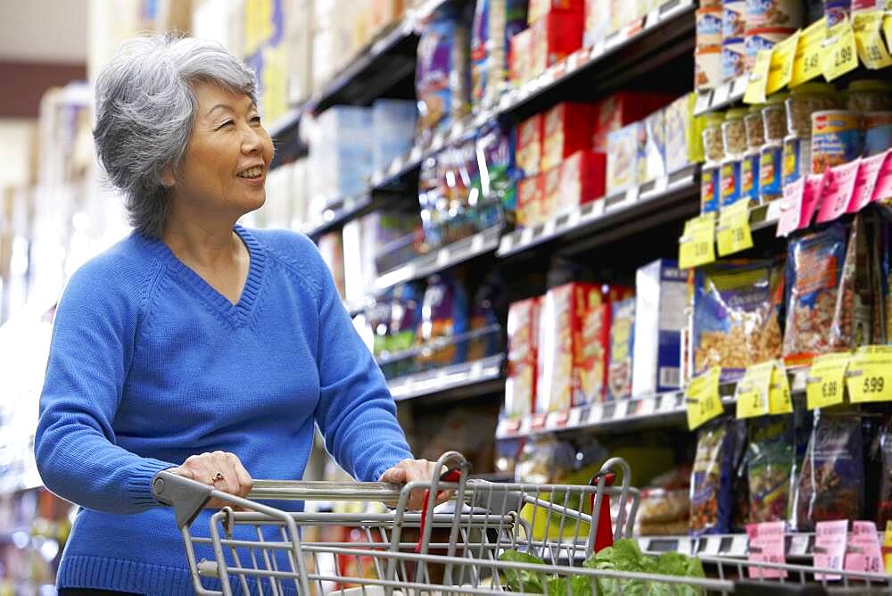 Senior Asian woman shopping in grocery store