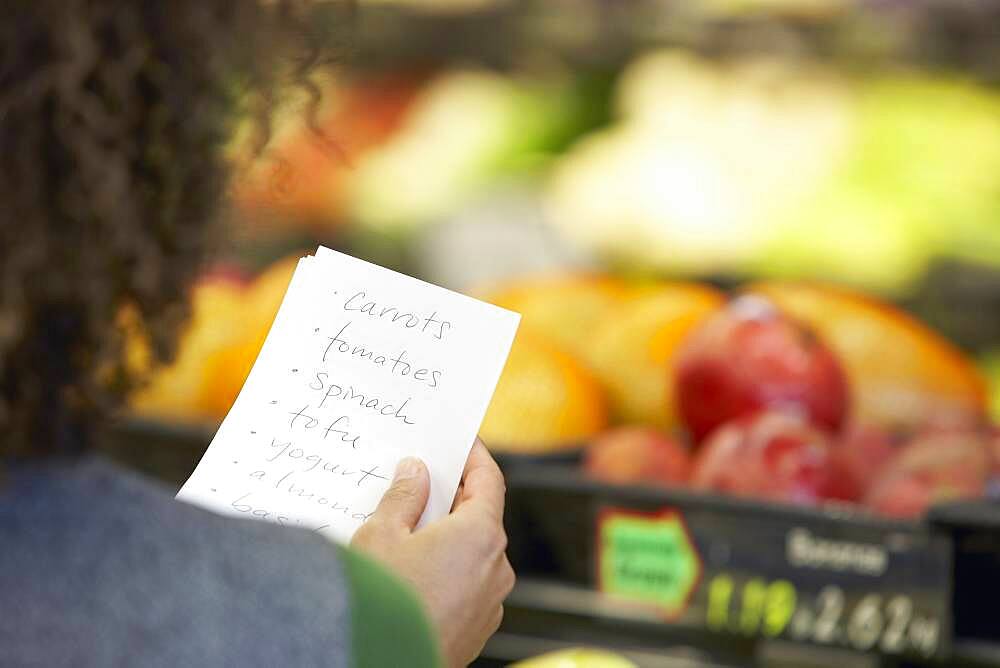 African woman reading grocery list