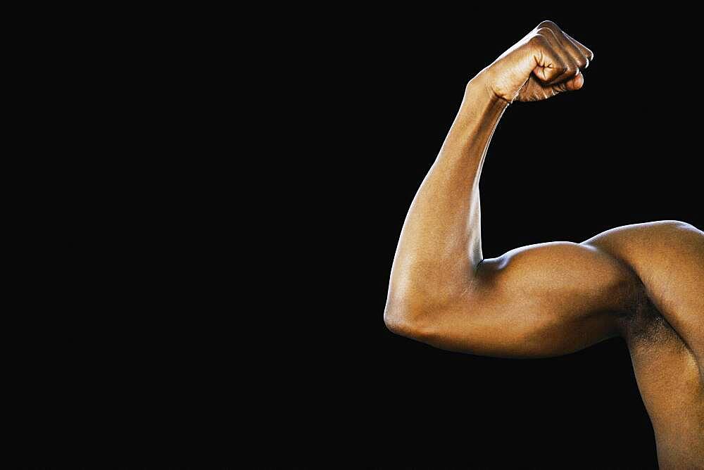 Studio shot of African man flexing biceps