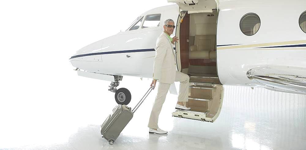 Middle-aged man boarding airplane in hanger