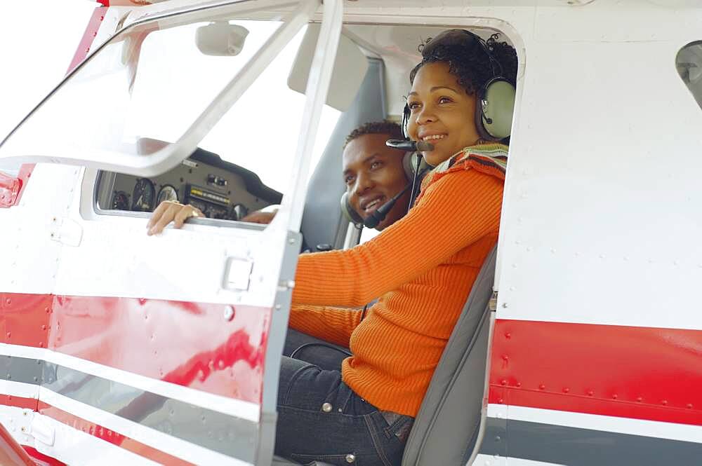 African couple in cockpit of airplane