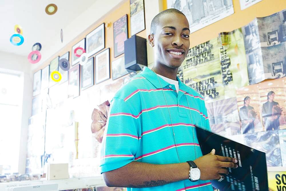 Teenage boy holding vinyl in a music store