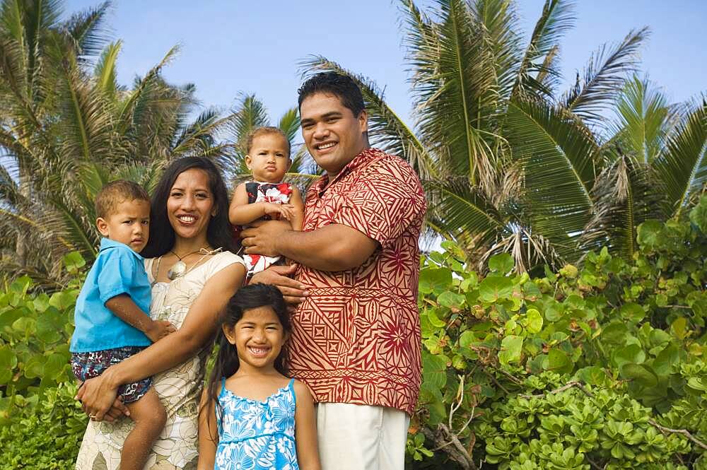 Pacific Islander family in front of palm trees