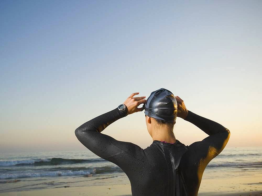 Rear view of Hispanic woman wearing wetsuit