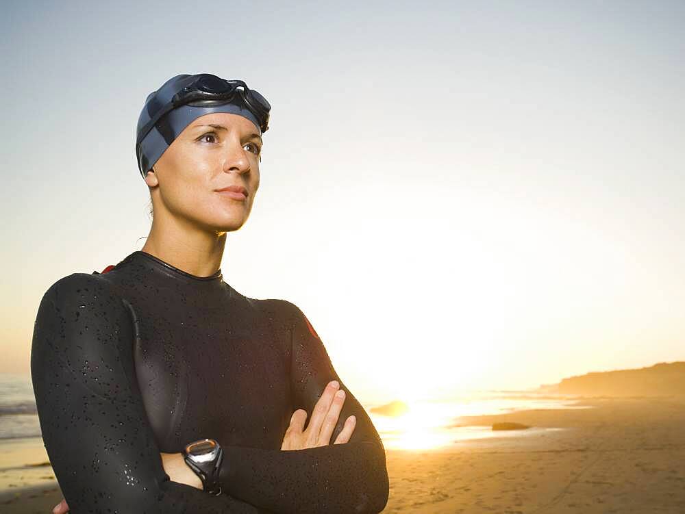 Hispanic woman wearing wetsuit and goggles