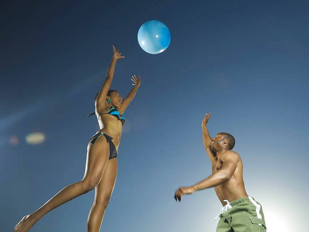 African American couple playing with beach ball