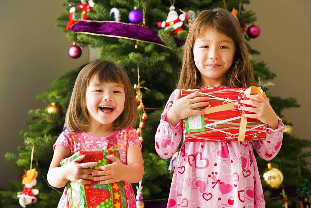 Two young sisters with Christmas presents