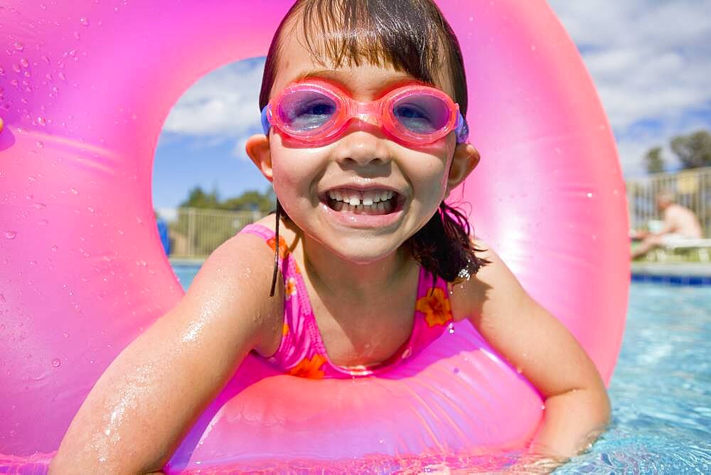 Portrait of girl in swimming pool wearing goggles