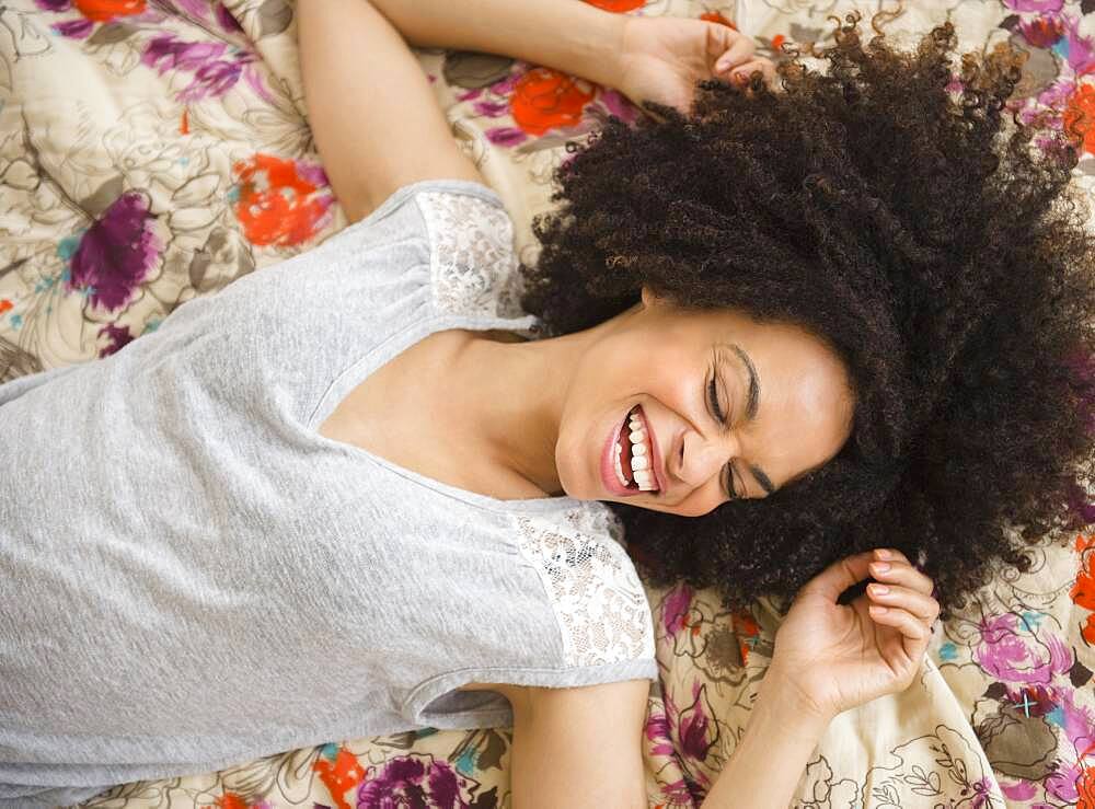 Mixed race woman laying on bed