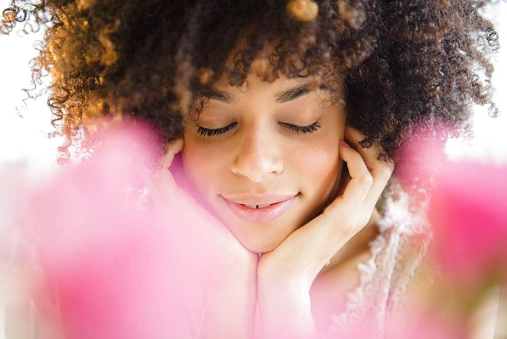 Mixed race woman resting chin in hands